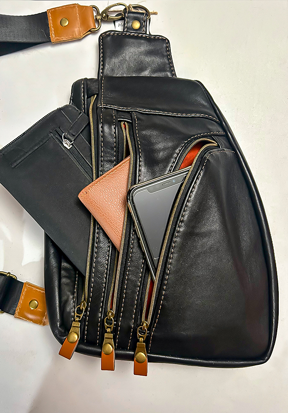 Handcrafted crossbody bag made from upcycled leather with adjustable strap and easy-access zipper pockets