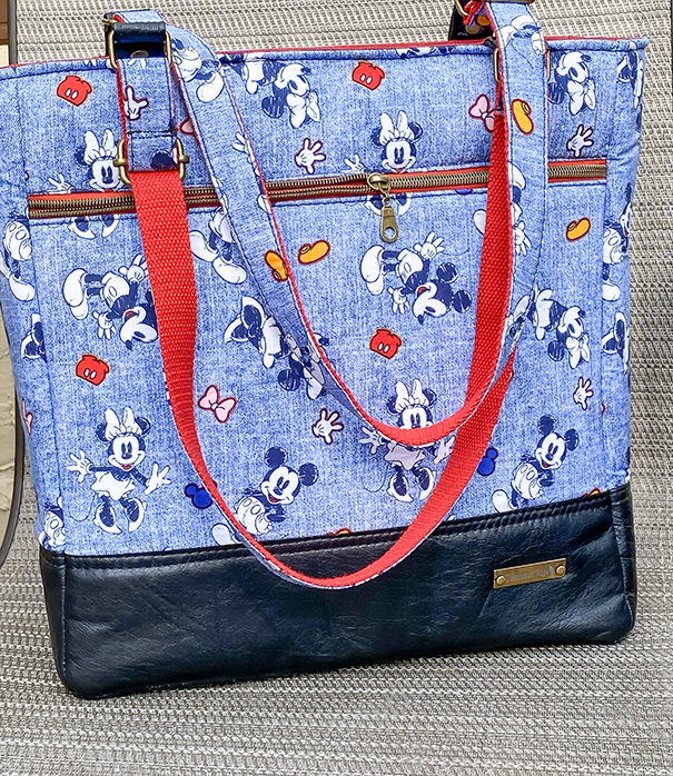 Custom handmade tote for a Disney lover featuring black upcycled leather and a Disney print, designed as a one-of-a-kind bag with quality materials and everyday functionality