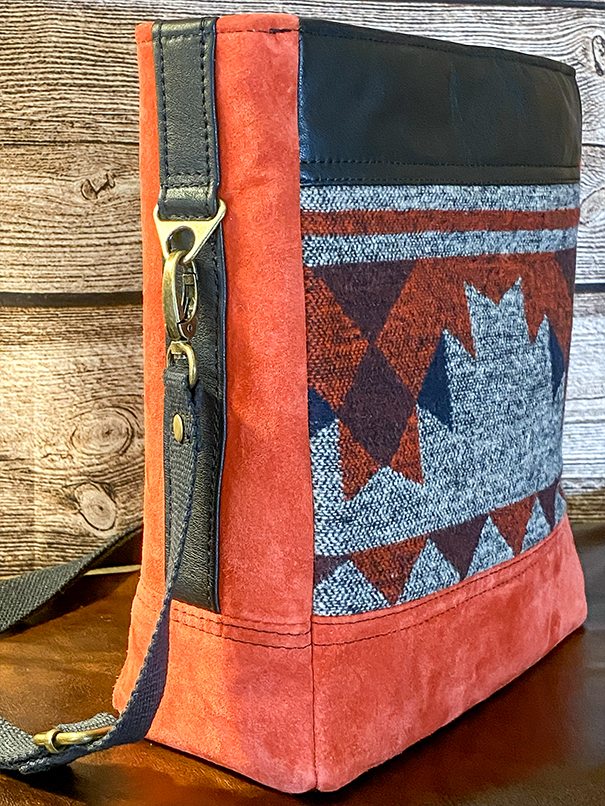 Handmade leather tote with Native American-inspired design, carry handles, shoulder strap, and functional interior storage