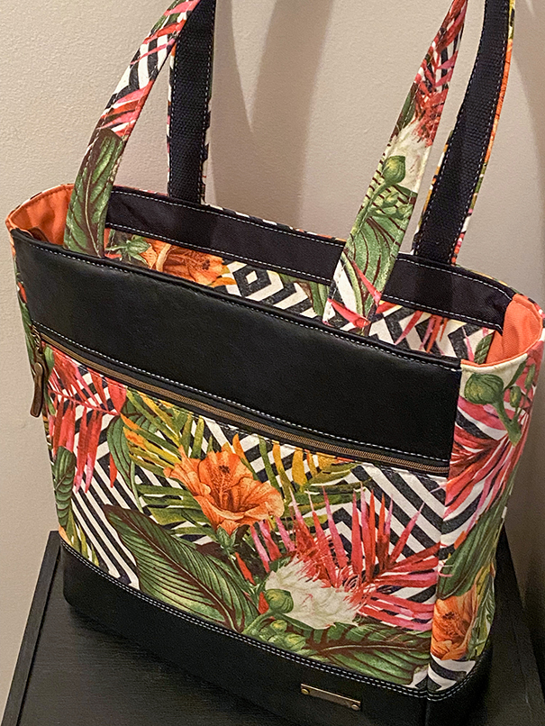 One-of-a-kind handmade leather tote with vibrant floral accents, shoulder strap, carry handles, and thoughtfully designed interior pockets