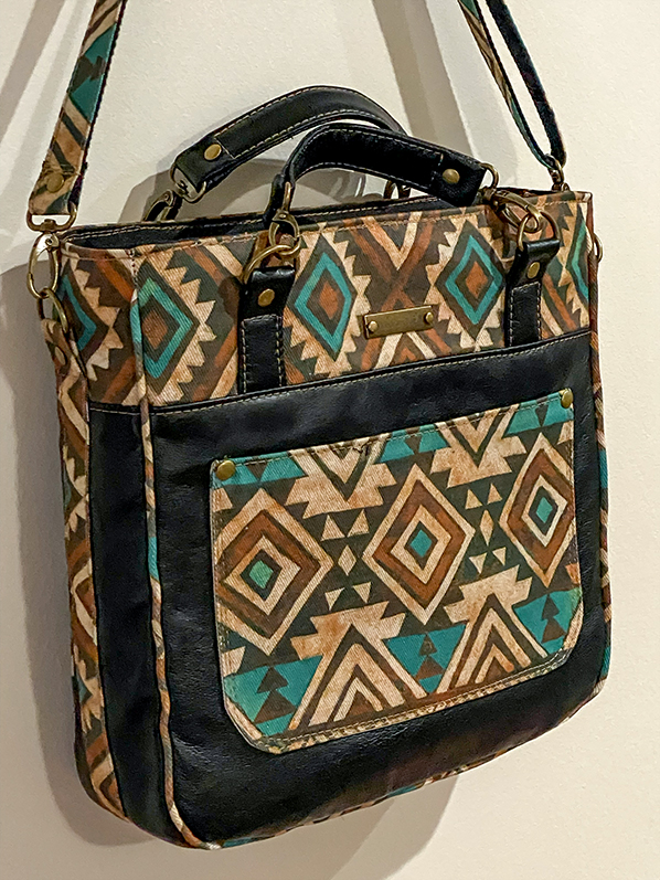 Custom leather purse with Native American-inspired design elements, shoulder strap, and secure zipper pockets